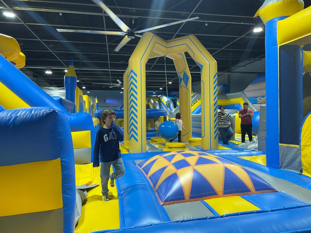 Indoor inflatable playground with blue and yellow structures, arches and walkways