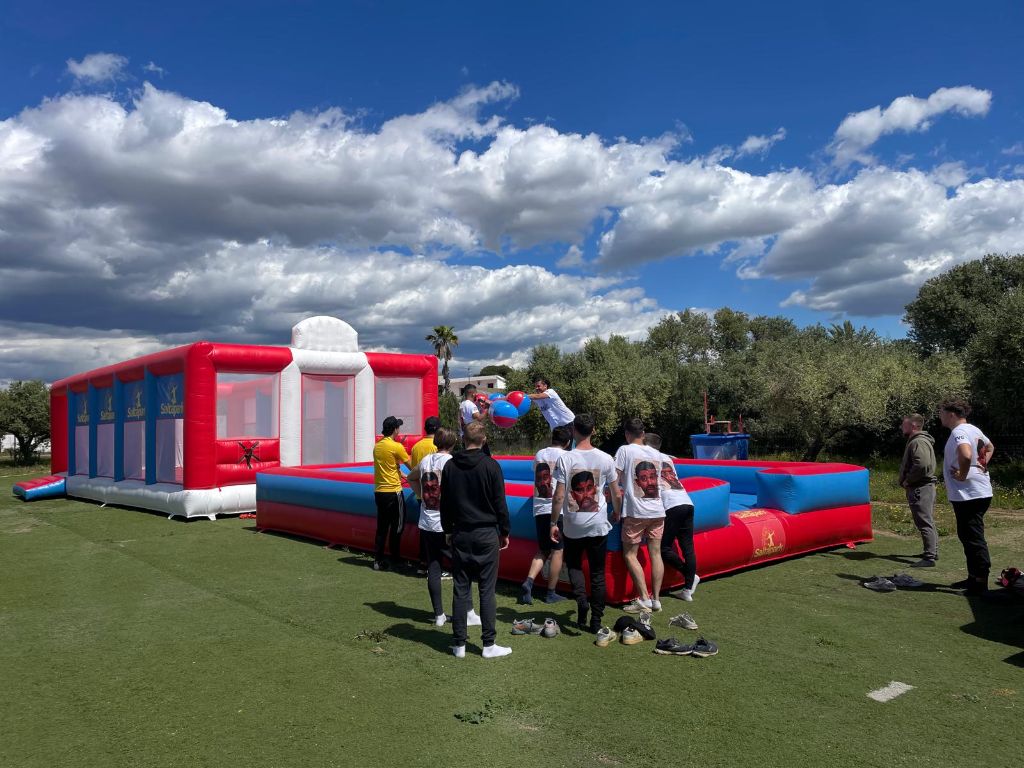 Wipeout inflatable challenge with participants and spectators on outdoor field
