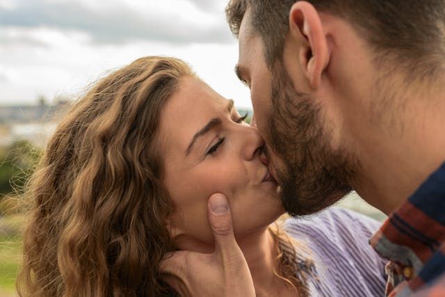 Intimate moment between couple about to kiss in natural outdoor setting