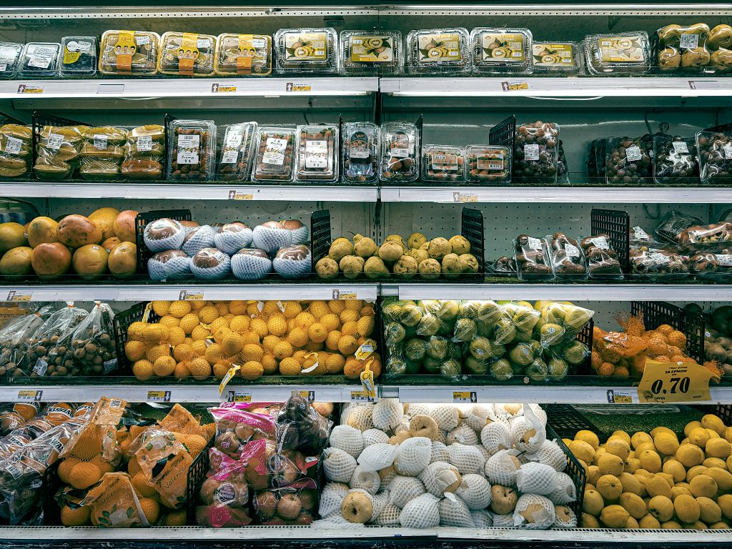 Fruits and vegetables in plastic packaging at supermarket
